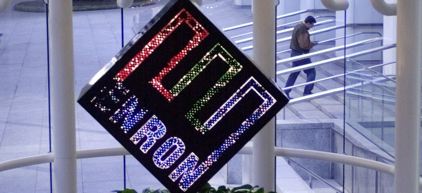 A colorful revolving Enron Corp. logo spins in the lobby of the enrgy company's downtown Houston headquarters in a file photo from Feb. 11, 2002, as an unidentified man enters the building. 