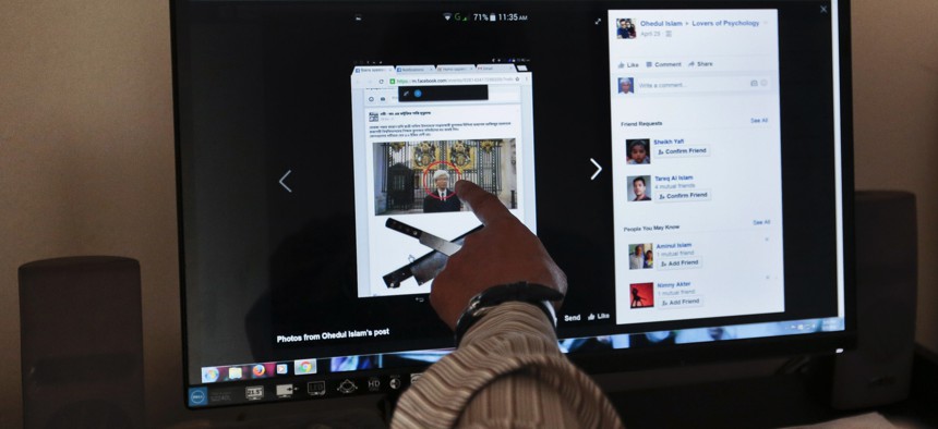 A Dhaka University professor Azizur Rahman points to a social media post at his home in Dhaka, Bangladesh, May 3, 2016.