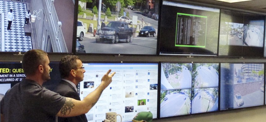 In this Friday, May 20, 2016 photo, Hartford police Sgt. Johnmichael O'Hare, left, shows Connecticut Gov. Dannel P. Malloy the police department's Real-Time Crime and Data Intelligence Center in Hartford, Conn.