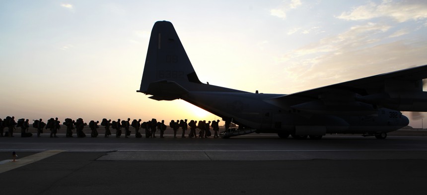 Marines and sailors with Marine Expeditionary Brigade in Afghanistan load onto a KC-130 aircraft on the Camp Bastion flightline, Oct. 27, 2014.
