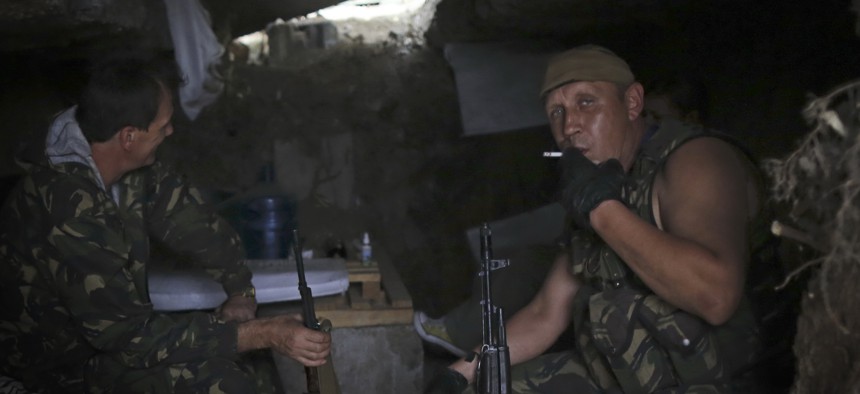 Pro-Russian rebels rest inside a shelter at their position outside Donetsk, eastern Ukraine, Friday, Aug. 22, 2014. Tensions between Russia and Ukraine escalated sharply on Friday as Moscow sent more than 130 trucks rolling across the border.