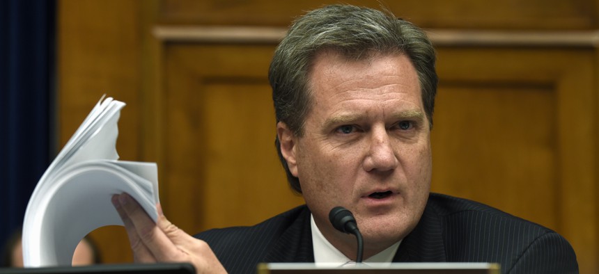House Oversight and Government Reform Committee member Rep. Mike Turner, R-Ohio holds up a security form as he asks questions during the committee's hearing on recent cyber attacks at OPM, Wednesday, June 24, 2015, on Capitol Hill.