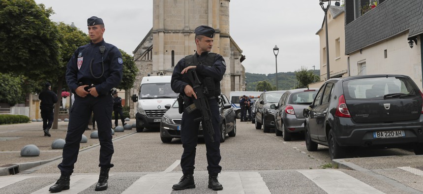 Police officers prevent the access to the church where an hostage taking left a priest dead the day before in Saint-Etienne-du-Rouvray, Normandy, France, Wednesday, July 27, 2016.