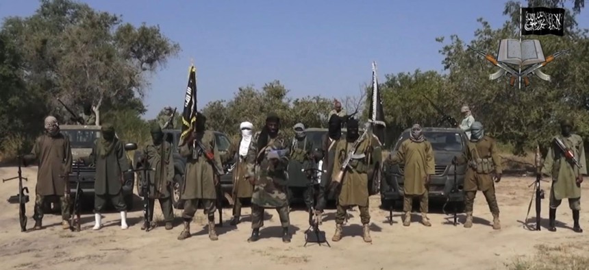 In his file image taken from video released late Friday evening, Oct. 31, 2014, by Boko Haram, Abubakar Shekau, centre, the leader of Nigeria's Islamic extremist group. 