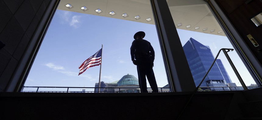 A State Capitol police officer stands watch from the Legislative Building during a Moral Monday rally outside the North Carolina Legislature in Raleigh, N.C., Monday, June 20, 2016. 