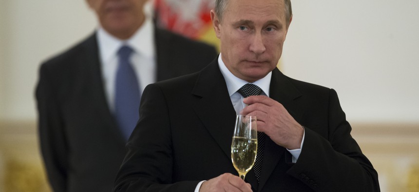In a file photo from 2014, Russian President Vladimir Putin prepares to toast with ambassadors in the Grand Kremlin Palace in Moscow, Russia.