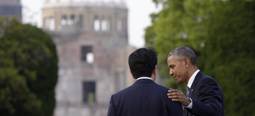 U.S. President Barack Obama, right, and Japanese Prime Minister Shinzo Abe speak with the Atomic Bomb Dome seen at rear at the Hiroshima Peace Memorial Park in Hiroshima, western Japan.