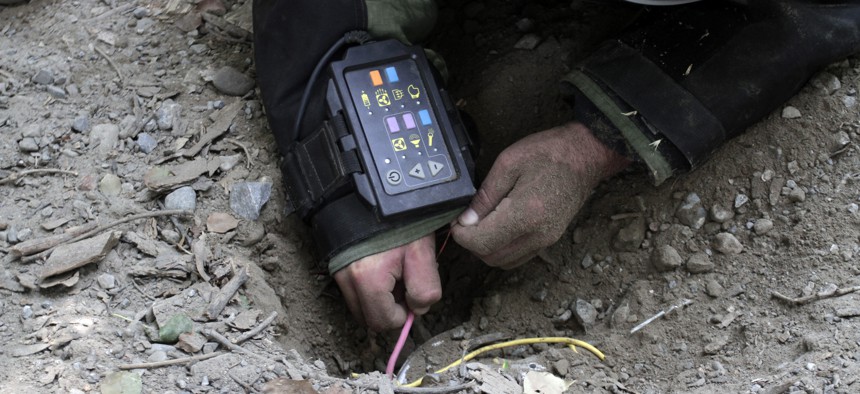 An Afghan soldier defuses IEDs at a training exercise in Jalalabad, east of Kabul, Afghanistan, Aug. 27, 2013.