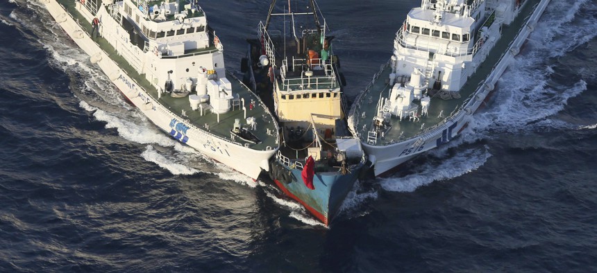 A boat, center, is surrounded by Japan Cost Guard's patrol boats after some activists descended from the boat on Uotsuri Island, one of the islands of Senkaku in Japanese and Diaoyu in Chinese, in East China Sea, Aug. 15, 2012. 