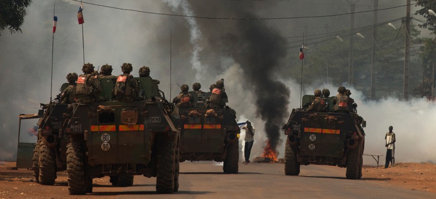 French soldiers fire tear gas as they attempt to contain a demonstration calling for the departure of French forces, in Bangui, Central African Republic, Dec. 22, 2013.
