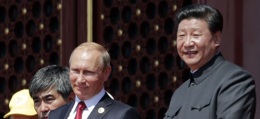 Chinese President Xi Jinping and Russian President Vladimir Putin observe a parade in Beijing, Sept. 3, 2015.