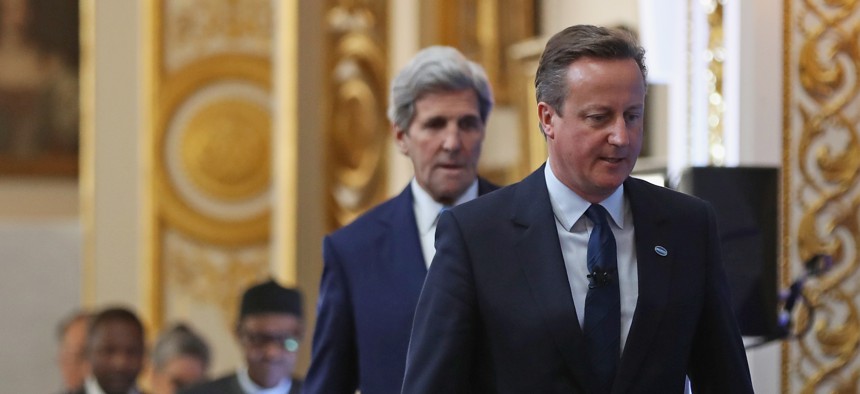 British Prime Minister Cameron, right, followed by U.S. Secretary of State John Kerry arrive to open London Anti-Corruption Summit on May 12, 2016, in London. 