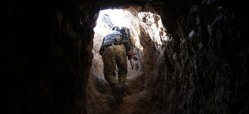 A peshmerga fighter walks through a tunnel made by Islamic State fighters, Tuesday, Oct. 18, 2016.