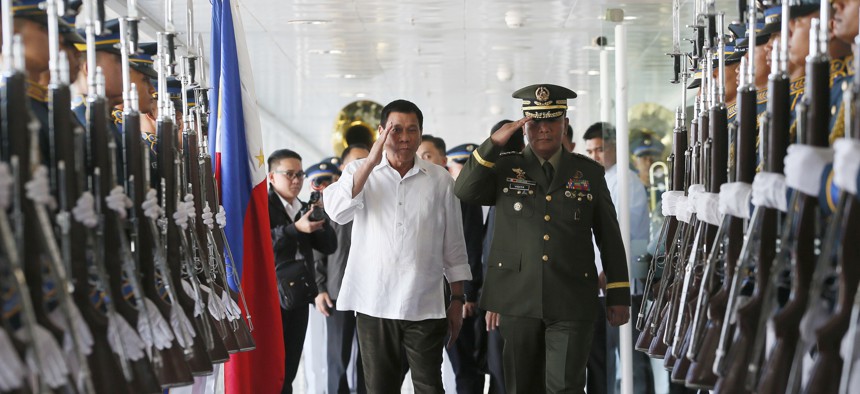 Philippine President Rodrigo Duterte, salutes with Armed Forces Chief Gen. Ricardo Visaya before boarding his Pasay city flight to Japan, Oct. 25, 2016.