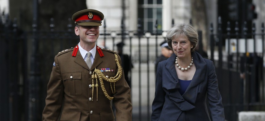 Britain's Prime Minister Theresa May walks with Col. John Clark a Military Advisor at 10 Downing Street in London, Sept. 22, 2016.