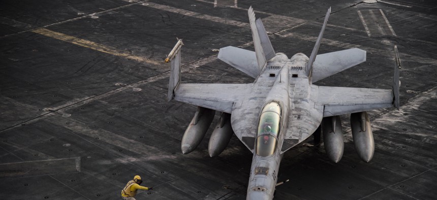 An F/A-18F Super Hornet deployed as part of Operation Inherent Resolve taxis across the flight deck the aircraft carrier USS Dwight D. Eisenhower.
