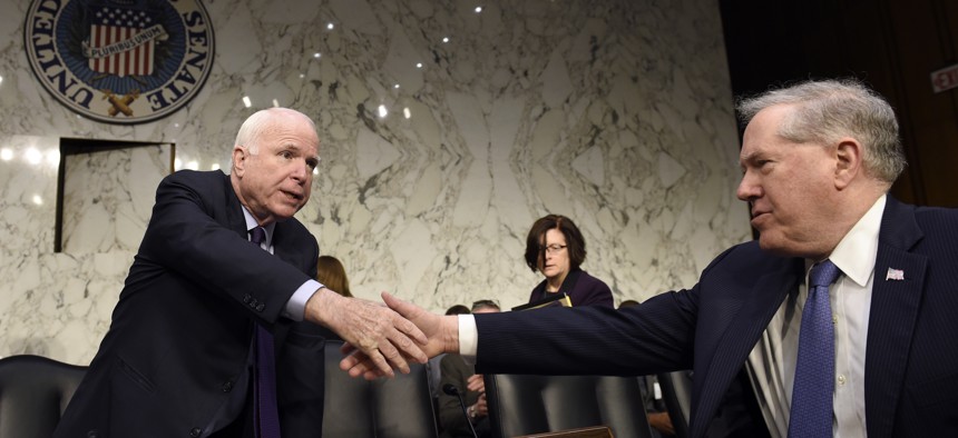Senate Armed Services Committee Chairman Sen. John McCain, R-Ariz., left, shakes hands with Defense Undersecretary Frank Kendall, the military's chief weapons buyer, right, before the start of a hearing on Capitol Hill in Washington, Jan. 27, 2016.