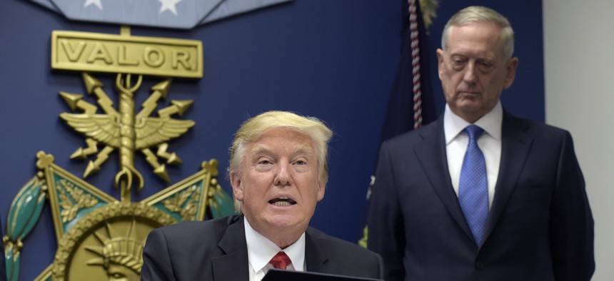 President Donald Trump, left, with Defense Secretary James Mattis, right, watching, explains the executive action on extreme vetting that he is about to sign at the Pentagon in Washington, Friday, Jan. 27, 2017. 