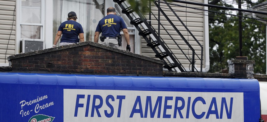 FBI agents walk around the roof outside an apartment during an investigation at a building, Sept. 19, 2016, in Elizabeth, N.J. FBI agents are searching the apartment that tied to Ahmad Khan Rahimi wanted for questioning in the New York City bombing.