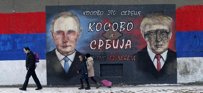 People walk by graffiti depicting the Russian President Vladimir Putin, left, and then-US President-elect Donald Trump, in Belgrade, Serbia, Jan. 20, 2017. 