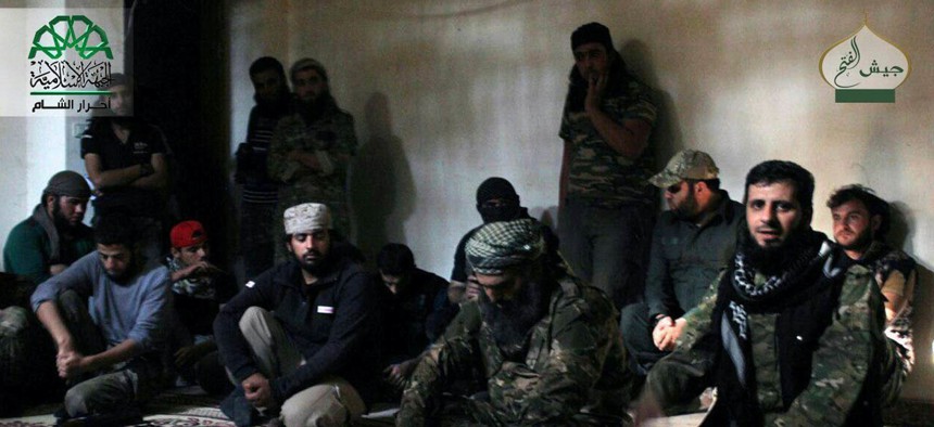 n this file photo posted, Sunday, Oct. 30, 2016, by the Syrian militant group Ahrar al-Sham, shows the general commander of Ahrar al-sham, Mohannad al-Masri, center, visiting fighters in rural western Aleppo, Syria. 