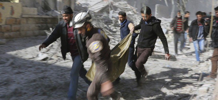 The real "White Helmets, Syrian Civil Defense workers and Syrian citizens carry a dead body in the neighborhood of Seif al-Dawleh in Aleppo, Syria, Saturday, Nov. 19, 2016. 