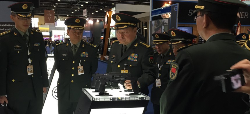 A Chinese military officer looks at a Sig Sauer handgun at the IDEX arms expo in Abu Dhabi in 2015.