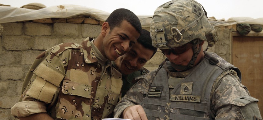 n this March 13, 2009 file photo, Iraqi Army soldiers look at a book of Arabic phrases as U.S. Army Staff Sgt. Robert Williams, 37, assigned to Delta Co., 1st Combined Arms Battalion, 67th Armor Regiment, looks for help in communicating in Mosul.