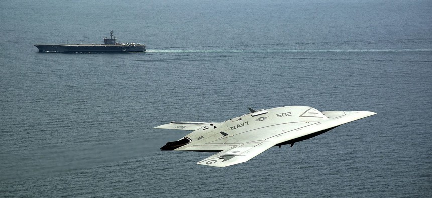 n X-47B Unmanned Combat Air System (UCAS) demonstrator flies near the aircraft carrier USS George H.W. Bush.