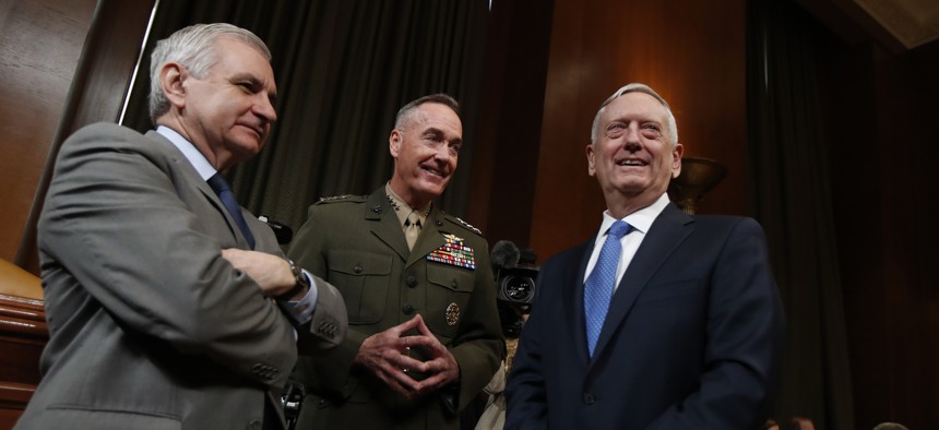 Joint Chiefs Chairman Gen. Joseph Dunford and Defense Secretary Jim Mattis confer with Sen. Jack Reed, D-R.I. (left), before testifying at the Senate Appropriations defense subcommittee. 