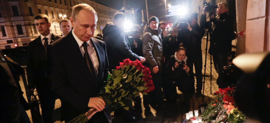 Russian President Vladimir Putin, second left, lays flowers at a place near the Tekhnologichesky Institut subway station in St.Petersburg, Russia, Monday, April 3, 2017.
