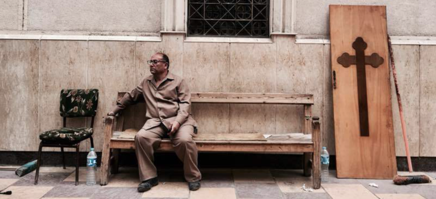 A man sits on a bench outside a church after a bomb attack in the Nile Delta town of Tanta, Egypt, Sunday, April 9, 2017. 