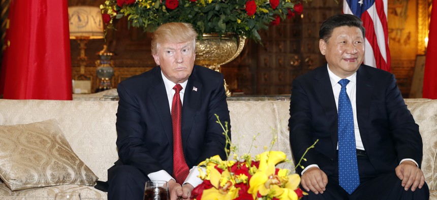 President Donald Trump and Chinese President Xi Jinping, sit as they pose for photographers before a meeting at Mar-a-Lago on April 6, 2017, in Palm Beach, Fla.