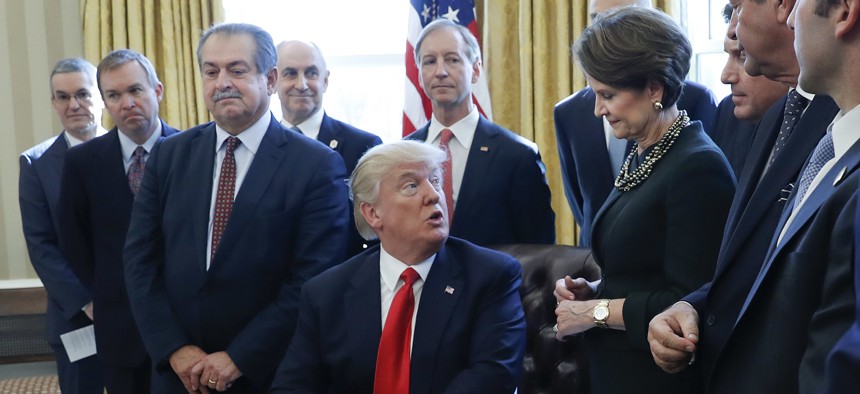 President Donald Trump looks over to Marillyn Hewson, Lockheed Martin chairman, CEO and president, before signing an executive order in the Oval Office on Feb. 24.