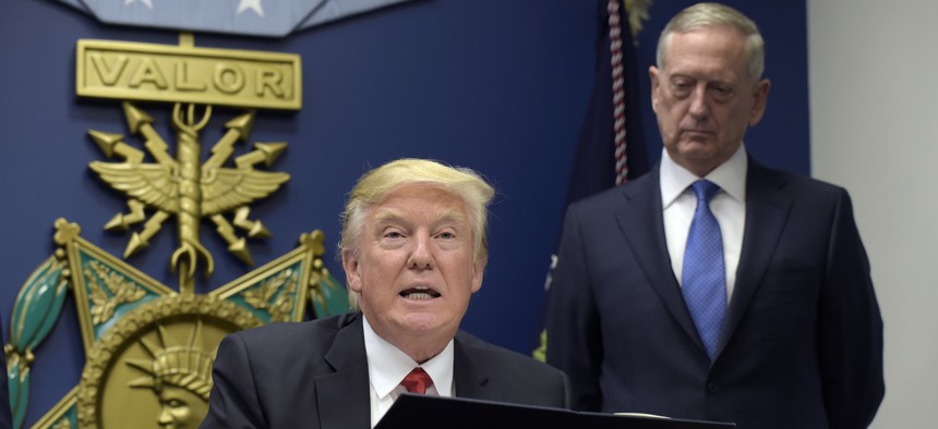 President Donald Trump, left, with Defense Secretary James Mattis, right, watching, explains the executive action on extreme vetting that he is about to sign at the Pentagon in Washington, January 27, 2017. 