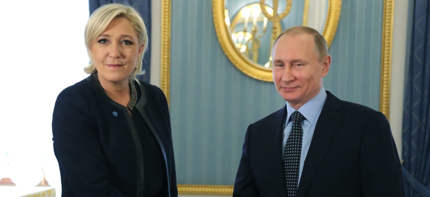 Russian President Vladimir Putin, right, shakes hands with French far-right presidential candidate Marine Le Pen, in the Kremlin in Moscow, Russia, Friday, March 24, 2017