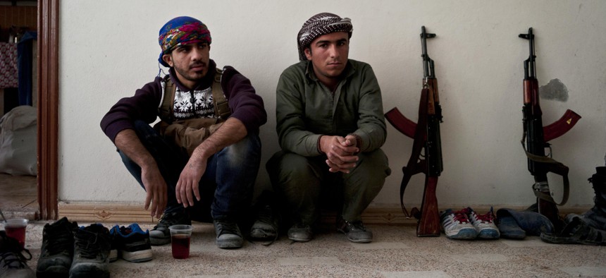 In this Nov. 1, 2014 photo, Kurdish fighters have a short tea break from fighting in Kobani, Syria. 