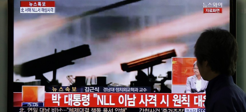 A man watches a television news program reporting about North Korea's live-fire artillery drills at a Seoul train station in Seoul, South Korea, Tuesday, April 29, 2014.