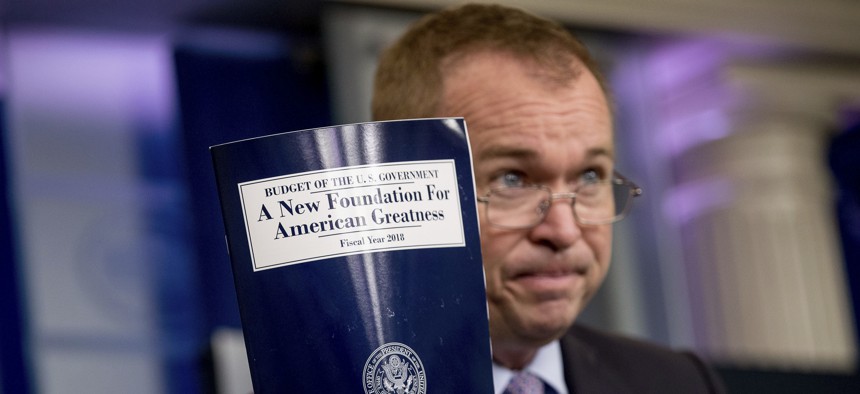 Budget Director Mick Mulvaney holds up a copy of President Donald Trump's proposed fiscal 2018 federal budget as he speaks to members of the media in the Press Briefing Room of the White House in Washington, Tuesday, May 23, 2017.