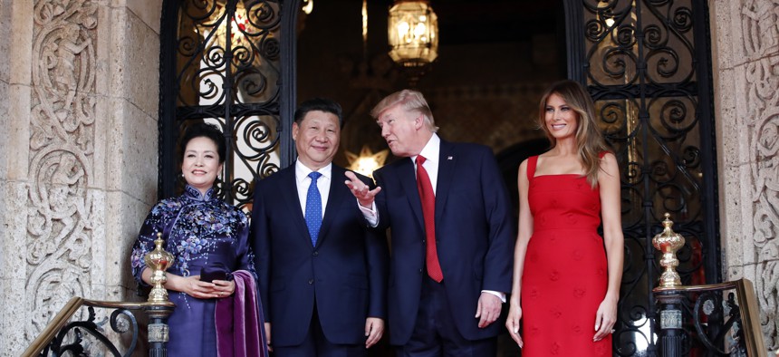 President Donald Trump talks with Chinese President Xi Jinping, with their wives, first lady Melania Trump and Chinese first lady Peng Liyuan as they pose for photographers before dinner at Mar-a-Lago, Thursday, April 6, 2017, in Palm Beach, Fla.