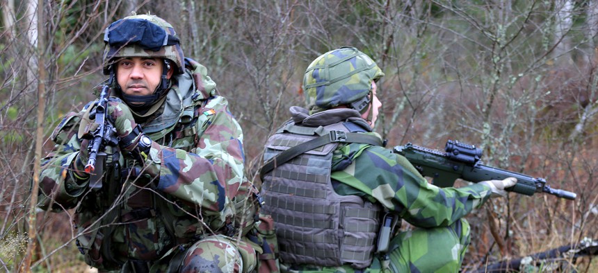 An Irish sergeant and a member of the Swedish Armed Forces participate in the EU Battle Group Sweden's Exercise Joint Action in 2014.