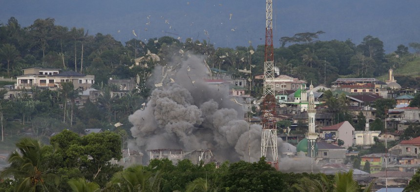 Debris fly as Philippine Air Force fighter jets bomb suspected locations of Muslim militants as fighting continues in Marawi city, southern Philippines, Friday, June 9, 2017. 