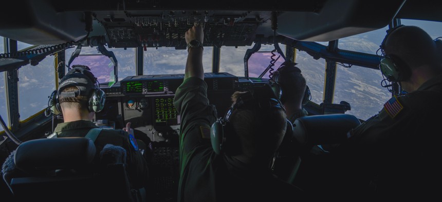 An Airman flips a switch during the first Yokota C-130J Super Hercules training sortie over the skies of Japan March 20, 2017. 