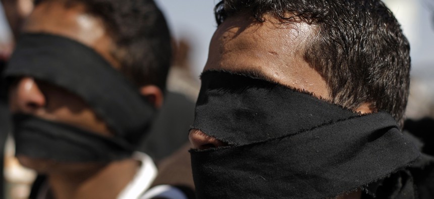 Protesters wear blindfolds to symbolize torture that they claim security forces commit against detained protesters during a demonstration demanding the prosecution of Yemen's President Ali Abdullah Saleh in Sanaa, Yemen, Friday, Dec. 30, 2011. 