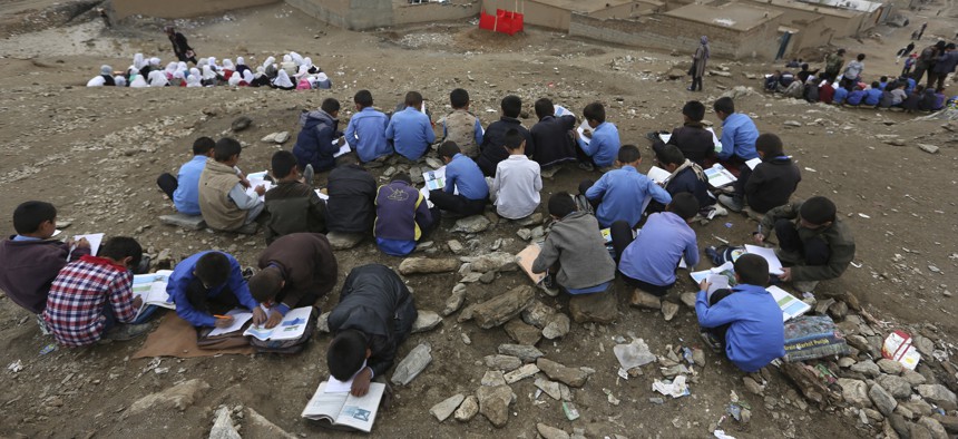 In this Wednesday, April 5, 2017, photo, Afghan students attend school classes an open air primary school on the outskirts of Kabul, Afghanistan.