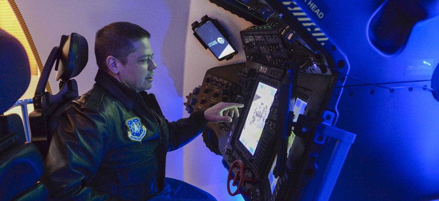 An astronaut from Air Force Space Command, pilots the Boeing Starliner simulator at the 33rd Space Symposium in Colorado Springs, Colo., April 6, 2017. 