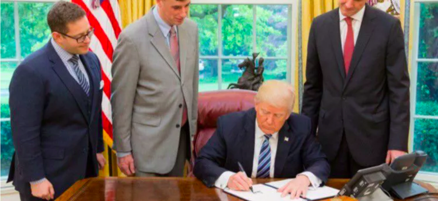 President Donald Trump signs a May 11, 2017, order on cybersecurity.