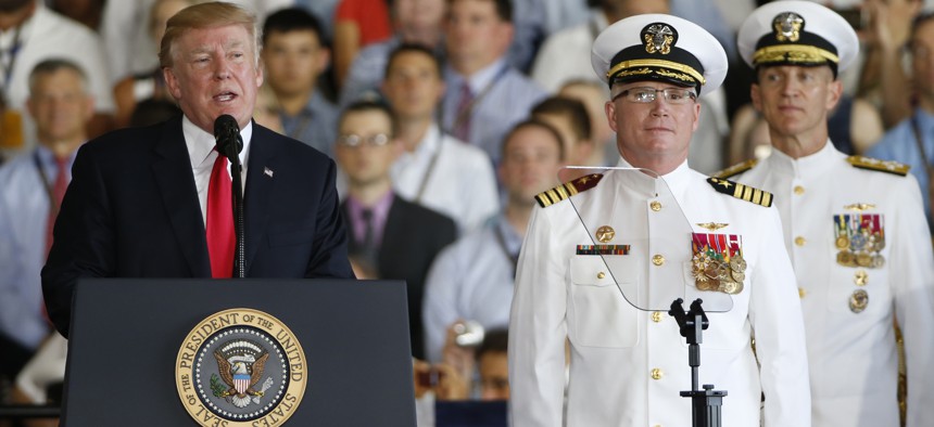 President Donald Trump, left, puts the USS Gerald Ford into commission as Ships commander Capt. Richard McCormack, front right, listens aboard the nuclear aircraft carrier USS Gerald R. Ford for it's commissioning at Naval Station Norfolk in Norfolk, Va.,