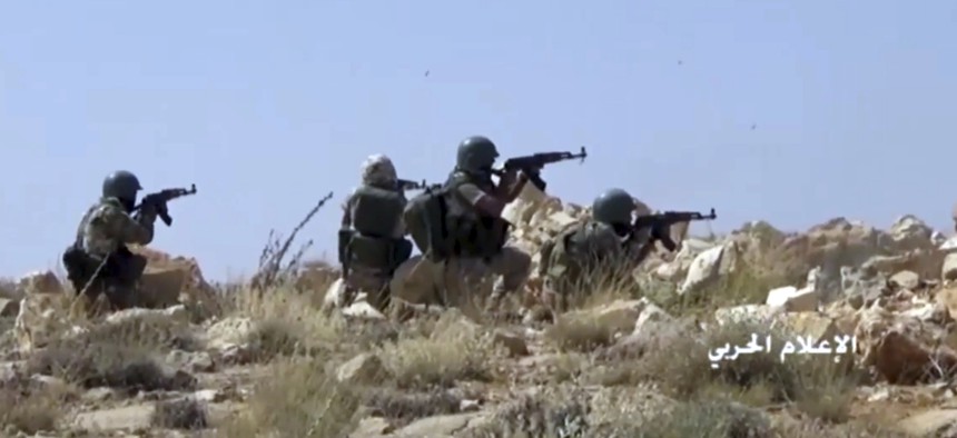 This frame grab from video released on Saturday, July 22, 2017 and provided by the government-controlled Syrian Central Military Media, shows Hezbollah fighters taking position during clashes with al-Qaida-linked militants in an area on the Lebanon-Syria 