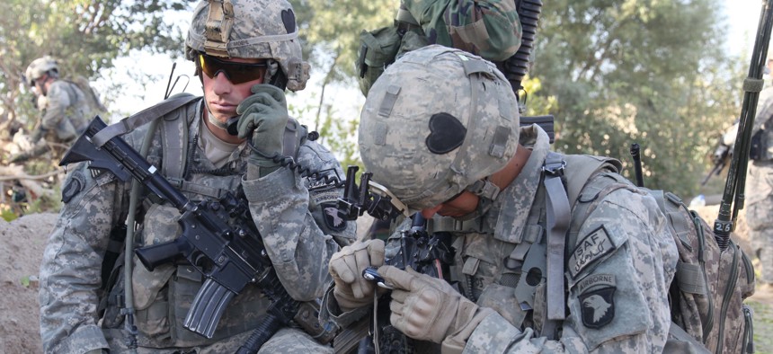 U.S. Army 1st Lt. Andrew Moehl of the 101st Airborne Division radios in his team's status with help from Spc. Joshua Rachal in Kandalay, Afghanistan, on Sept. 25, 2010.
